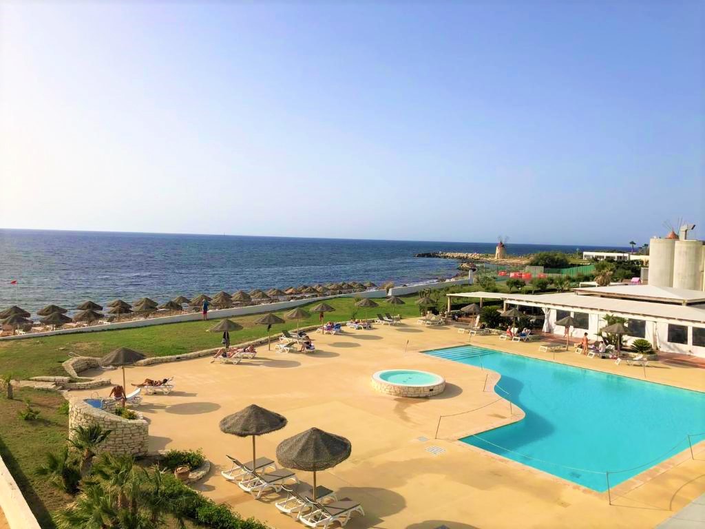 parasols en paille sur plage privée hotel piscine sicile